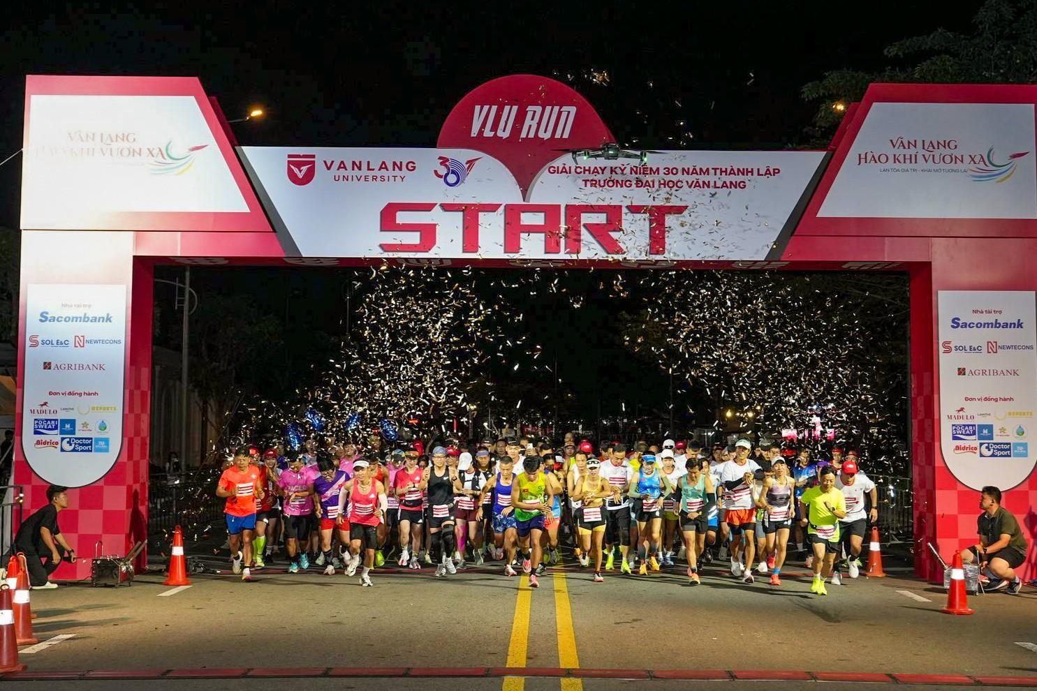 Runner xuất phát dưới cổng START và mưa kim tuyến tại VLU RUN 2025